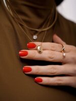 colar com pingente oval em ouro 18k e pedra topázio incolor sobre fundo marrom