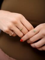 anel com esmeralda e brilhantes em ouro 18k usado nos dedos