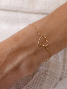 pulseira coração vazado em ouro 18k no pulso feminino