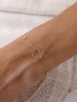pulseira coração vazado com bolinhas em ouro 18k no pulso feminino