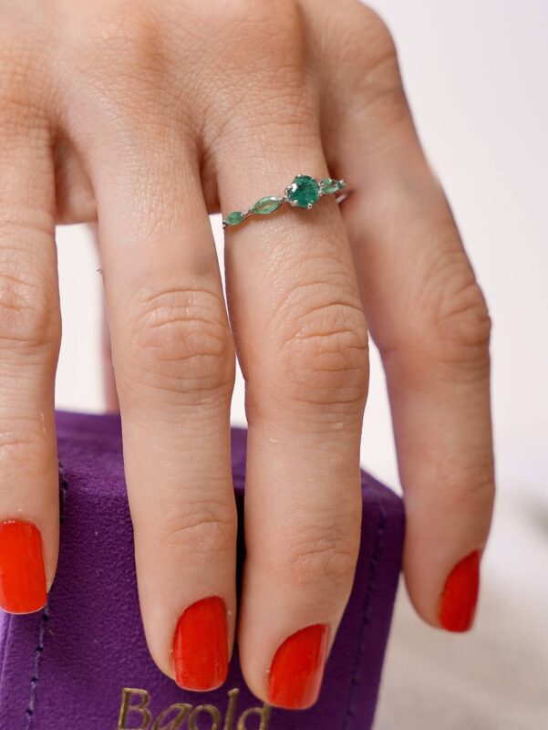 anel em ouro branco 18k com esmeralda central redonda e laterais em lapidação navete