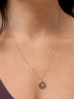 colar comprido olho grego estilizado em ouro 18k no colo feminino