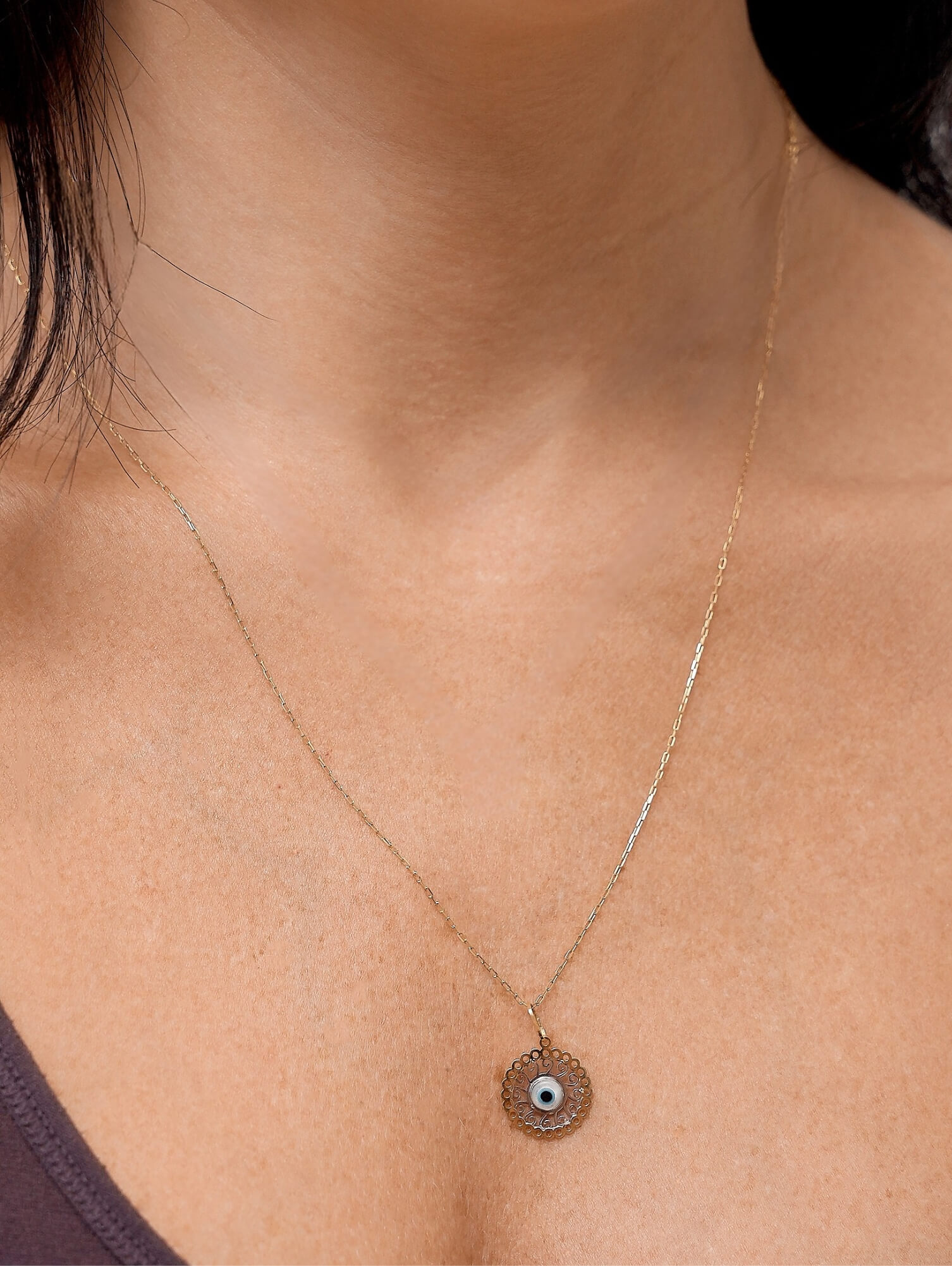 colar comprido olho grego estilizado em ouro 18k no colo feminino