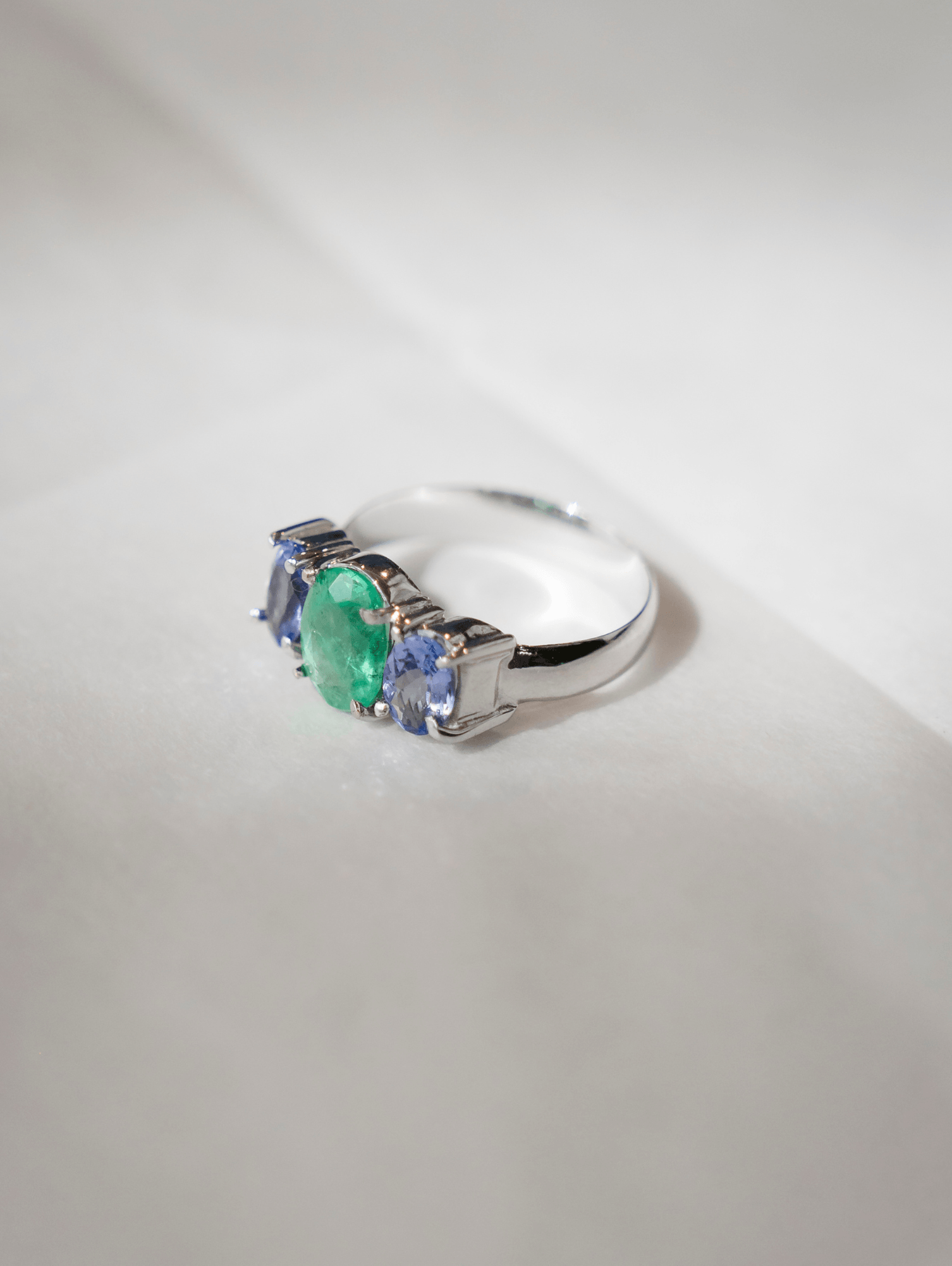 Anel em ouro branco 18k com esmeralda 6x8mm e tanzanitas 4x6mm